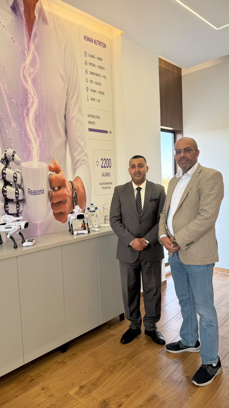 في مقر Reasonix — أمام جدارية «التغذية البشرية»